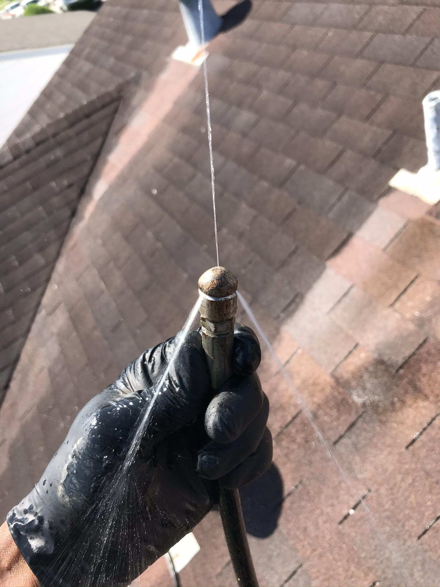 Hydro jetting nozzle clearing a drain line under high pressure